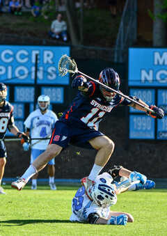 Mullins tries to evade UNC's Shane Simpson as the Tar Heels midfielder lies on the ground.