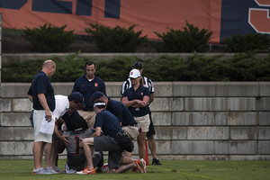 Julian Whigham lies on the ground in pain following an injury during the Fan Fest practice at SU Soccer Stadium.