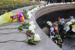 Remembrance scholars placed white roses along the Wall of Remembrance to pay tribute to students who died during Pan Am Flight 103