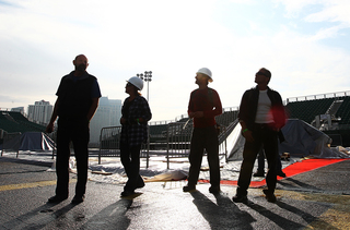 Workers look up towards the tower during preparations aboard the USS Midway Museum on Nov. 8, 2012, before the Battle on the Midway game between the Syracuse Orange and the San Diego State Aztecs scheduled for Sunday.