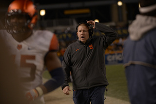 SU defensive line coach Tim Daoust gives instructions toward the sideline during Saturday's game.