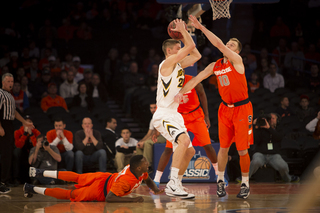 SU shooting guard Trevor Cooney pressues an Iowa player as Joseph pushes himself off of the floor. 